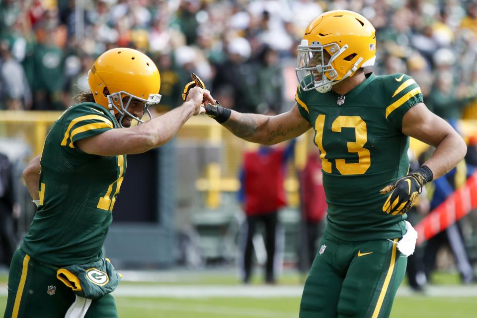 Green Bay Packers' Allen Lazard (13) celebrates his touchdown catch with Aaron Rodgers (12) during the first half of an NFL football game against the Washington Football Team Sunday, Oct. 24, 2021, in Green Bay, Wis. (AP Photo/Matt Ludtke)