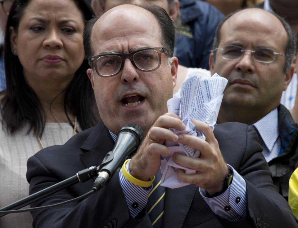 National Assembly President Julio Borges balls up Supreme Court documents ruling that it can take over responsibilities assigned to congress, during a press conference at the National Assembly in Caracas, Venezuela, March 30, 2017. In a decision late Wednesday night, the magistrates said that as long as lawmakers remain in contempt of past court rulings nullifying all legislation coming out of the opposition-controlled National Assembly, the high court can assume congressional duties itself. (AP Photo/Ariana Cubillos)