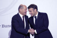 French President Emmanuel Macron, right, shakes hands with German Chancellor Olaf Scholz at the Sorbonne University during a ceremony to mark 60 years since a landmark treaty sealed a bond between the longtime enemies, Sunday, Jan. 22, 2023 in Paris. France and Germany are seeking to overcome differences laid bare by Russia's war in Ukraine and shore up their alliance with a day of ceremonies and talks Sunday on Europe's security, energy and other challenges. (AP Photo/Christophe Ena, Pool)