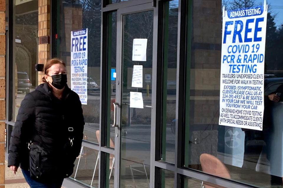 A pedestrian walks past a free COVID-19 PCR and rapid testing site in Glenview, Illinois, on Saturday, Dec. 25, 2021.