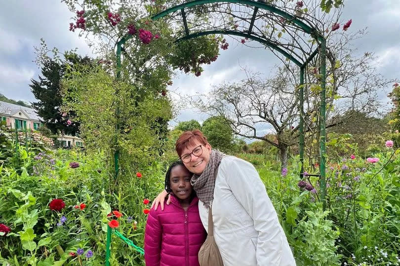 Susie and her grandaughter Riya posing in a garden