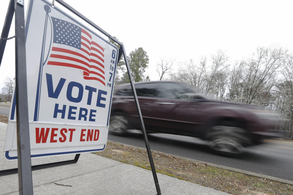 A car passes a polling precinct during the Democratic Presidential primary voting Tuesday, March 3, 2020, in Richmond, Va. (AP Photo/Steve Helber)