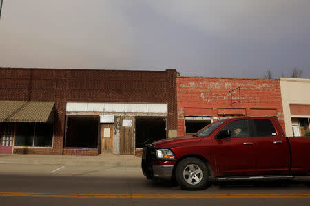 A man drives his truck past shuttered storefronts on the main street of Buffalo, Oklahoma, U.S., March 13, 2017. REUTERS/Lucas Jackson