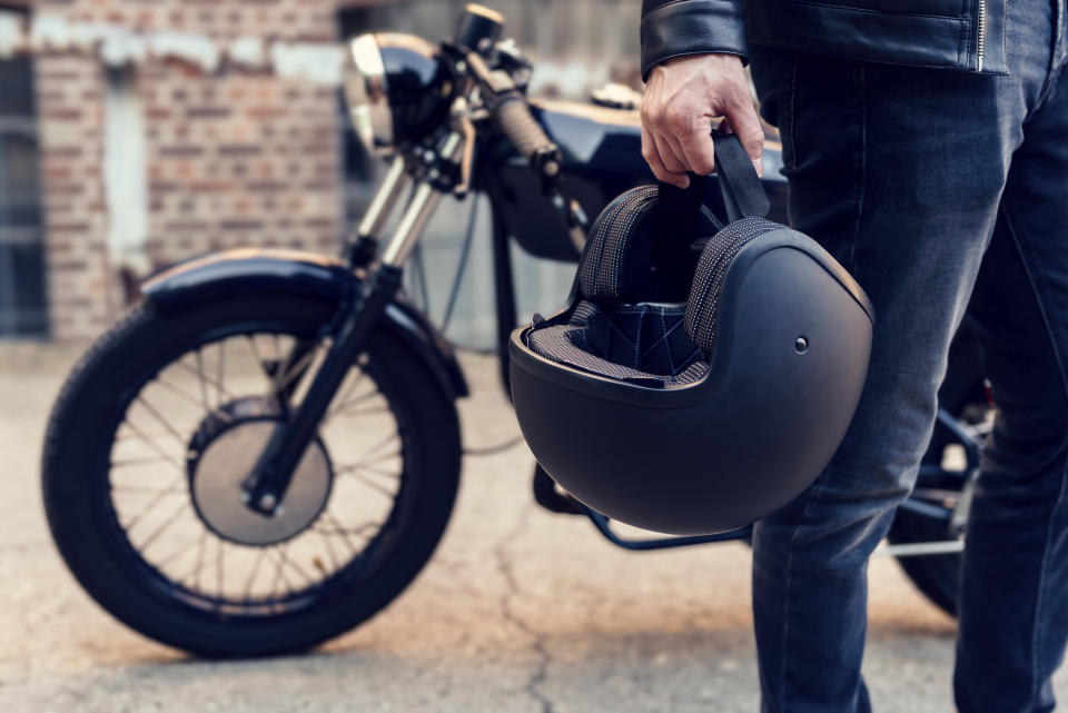 A motorcyclist carrying a helmet