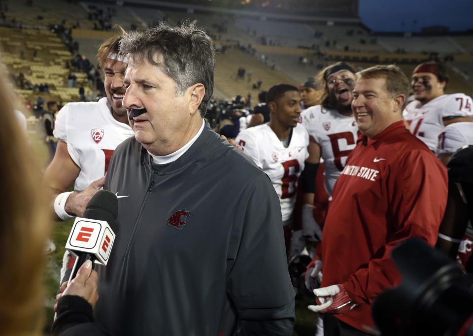 Washington State head coach Mike Leach wears a fake mustache placed on him by starting quarterback <a class="link " href="https://sports.yahoo.com/nfl/players/32010/" data-i13n="sec:content-canvas;subsec:anchor_text;elm:context_link" data-ylk="slk:Gardner Minshew;sec:content-canvas;subsec:anchor_text;elm:context_link;itc:0">Gardner Minshew</a>, back, during a television interview after an NCAA college football game against Colorado Saturday, Nov. 10, 2018, in Boulder, Colo. | David Zalubowski, Associated Press