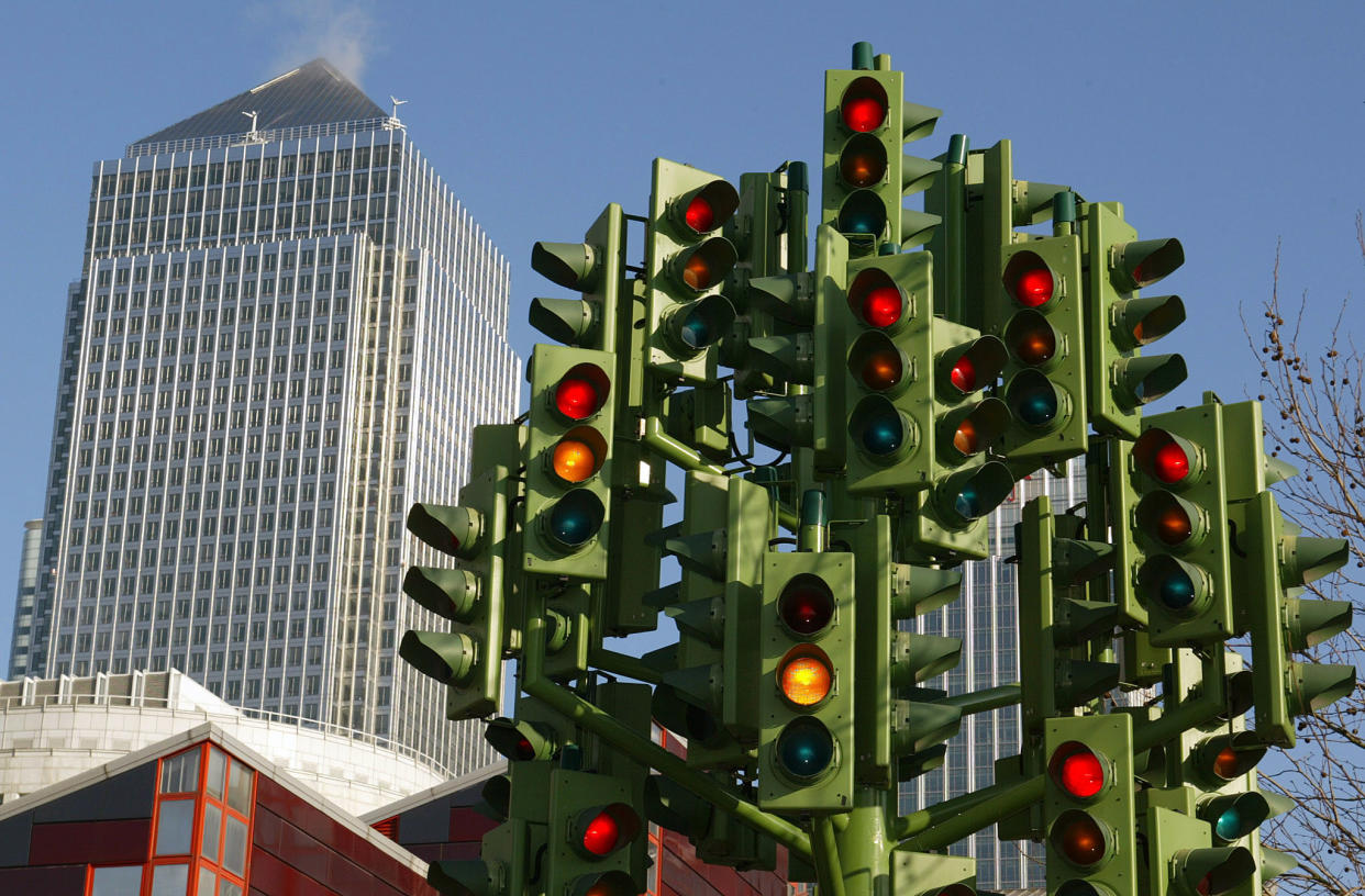 A sculpture representing dozens of traffic lights flashes on a roundabout at Canary Wharf, with the Canary Wharf tower behind, East London, February 17, 2003. Monday is the first day of the congestion charge - a fixed charge for most motorists entering central London. TPORT REUTERS/Toby Melville  TM