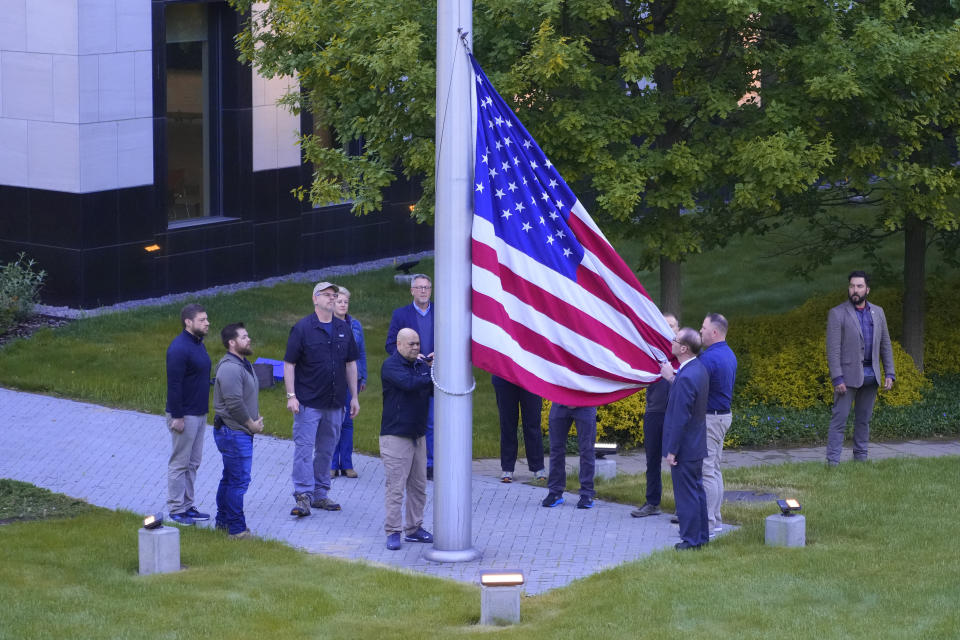 Employees of US embassy in Ukraine raise the US national flag at the US embassy, as Russia's attack on Ukraine continues, in Kyiv, Ukraine, Wednesday, May 18, 2022. (AP Photo/Efrem Lukatsky)