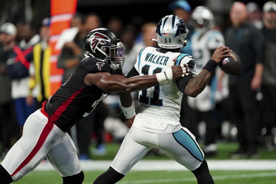 Carolina Panthers quarterback PJ Walker (11) throws under pressure from Atlanta Falcons linebacker Lorenzo Carter, left, during the second half of an NFL football game Sunday, Oct. 30, 2022, in Atlanta. (AP Photo/John Bazemore)