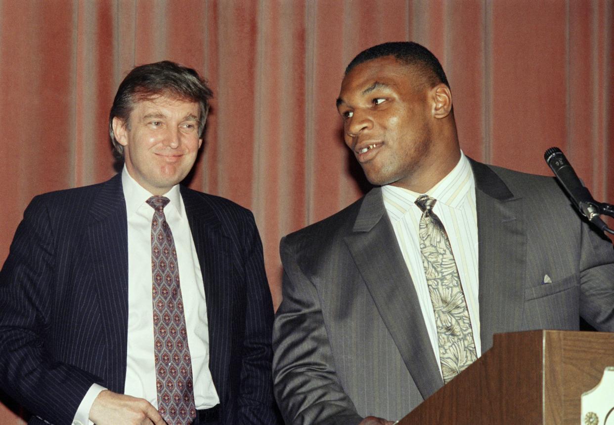 Heavyweight champion Mike Tyson, right, speak at a news conference while advisor Donald Trump looks in New York on July 27, 1988 after announcing a settlement between Tyson and his manager, Bill Cayton. Tyson, who had sued to break his contract with Cayton, reached an ou-of-court settlement under which Cayton will remain his manager until Feb. 11, 1992.
