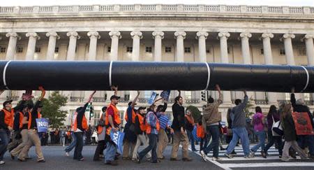 Demonstrators carry a giant mock pipeline while calling for the cancellation of the Keystone XL pipeline during a rally in front of the White House in Washington November 6, 2011. REUTERS/Joshua Roberts