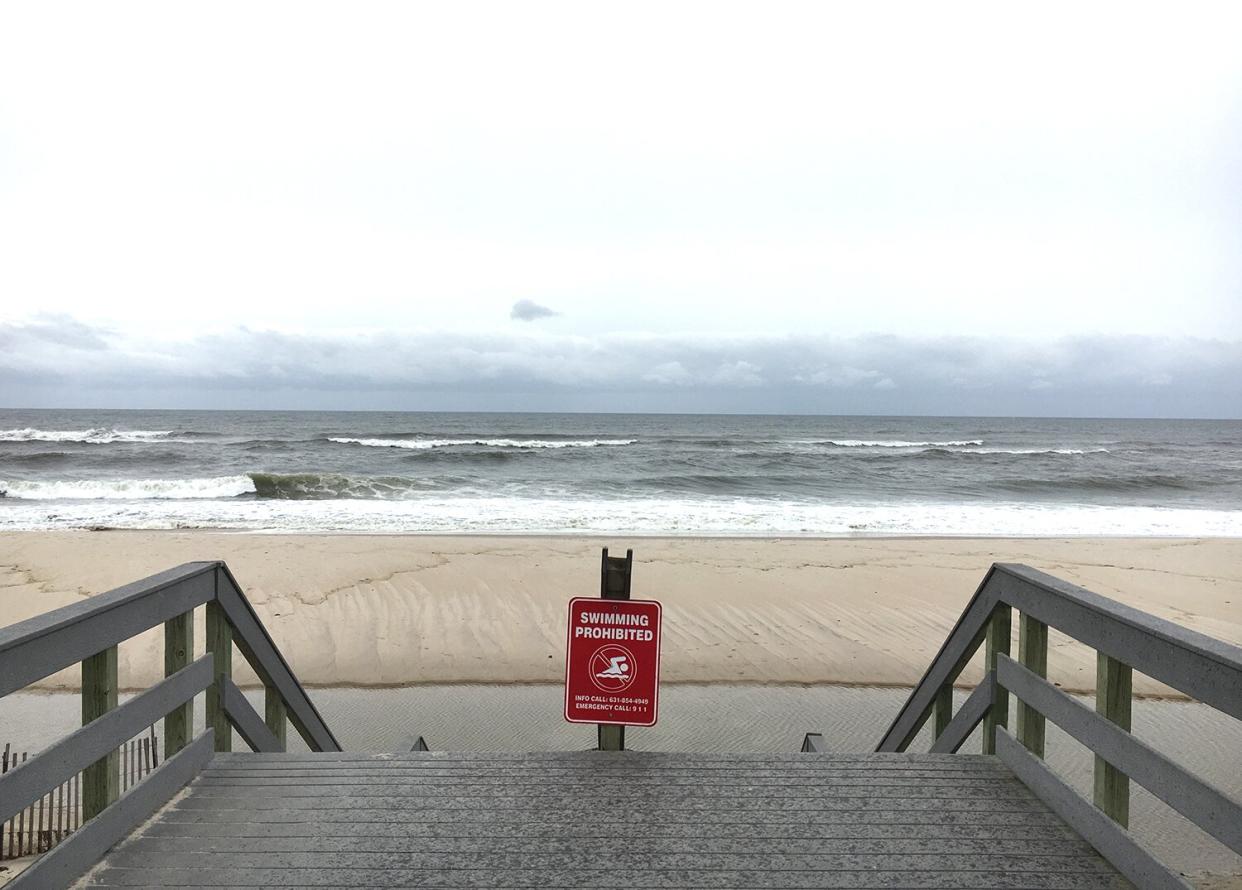 Smith Point Beach in Shirley, Long Island, NY. A red swimming prohibited sign on the stairs.