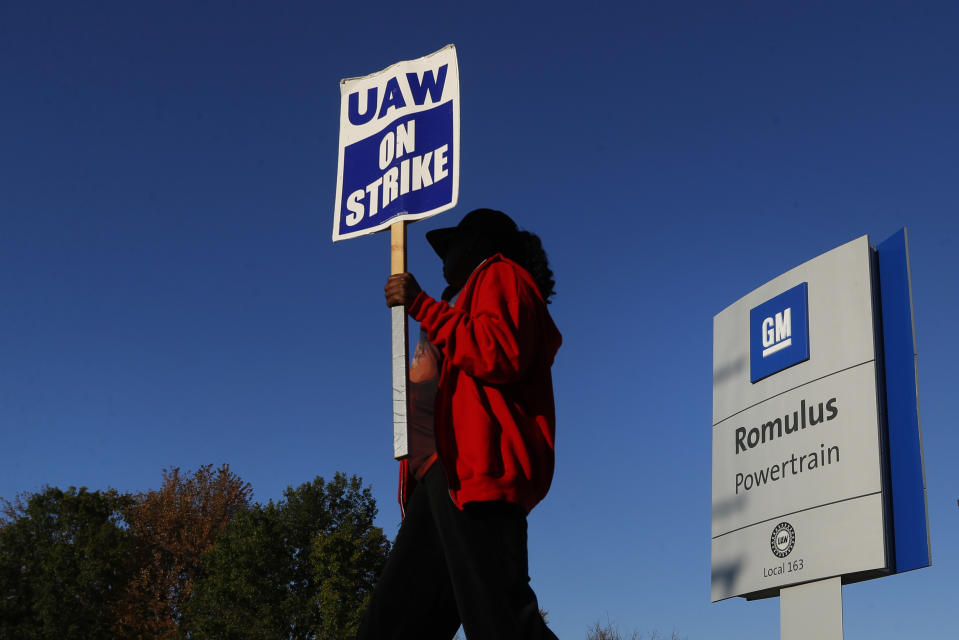 ARCHIVO - En esta foto de archivo del 9 de octubre de 2019, Yolanda Jacobs, miembro del sindicato automotor, lleva un cartel de "UAW en huelga" frente a una planta de General Motors en Romulus, Michigan, EE.UU. En el 30mo día de huelga, martes 15 de octubre de 2019, hay señales de un posible acuerdo. (AP Foto/Paul Sancya, File)