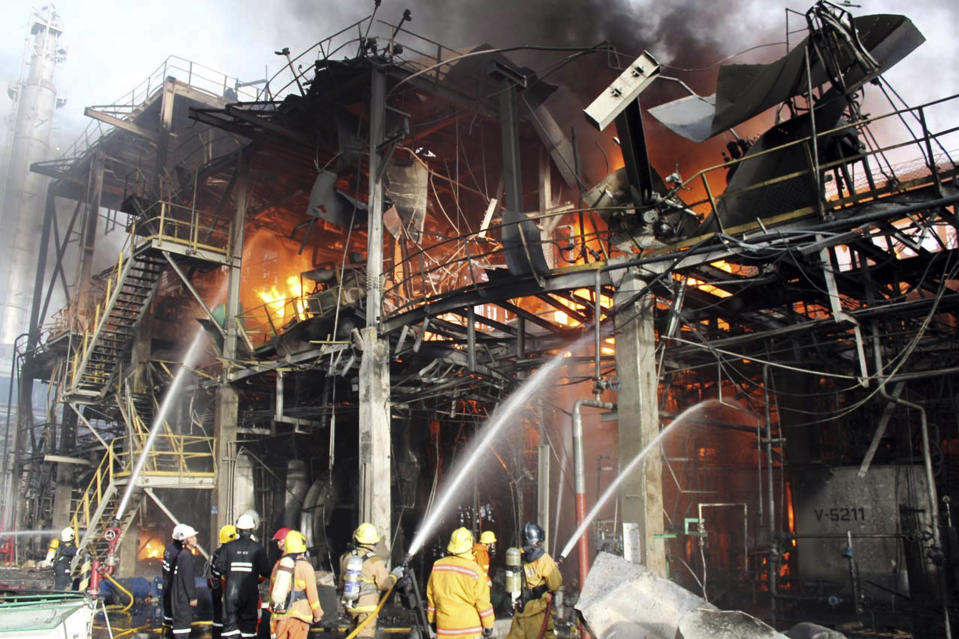 In this photo taken Saturday, May 5, 2012, Thai firefighters try to put off the fire after an explosion at a factory in Rayong province, Thailand. A fire caused by explosions in one of the world's largest petrochemical industrial estates have killed 12 and injured more than 100 people in eastern Thailand. (AP Photo)