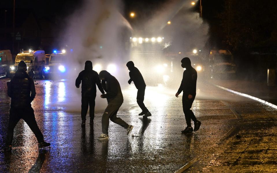 Nationalists attack police vehicles as they deploy water canons on Springfield Road just up from Peace Wall interface gates which divide the nationalist and loyalist communities on April 8, 2021 in Belfast - Charles McQuillan/Getty 