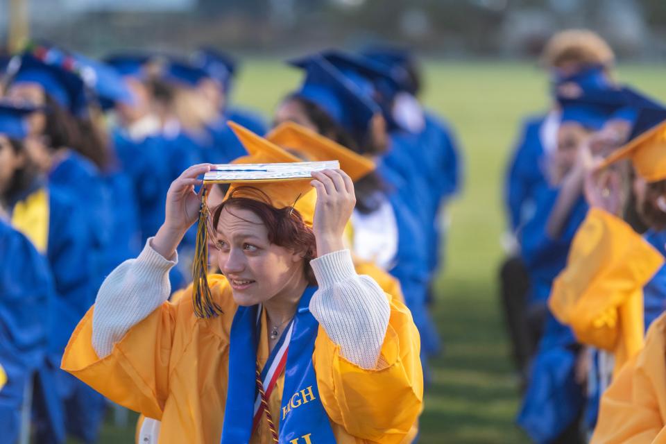 Graduates hang onto their caps in the wind during Serrano High School's Graduation Ceremony in Phelan CA on Thursday June 8, 2023. (James Quigg, for the Daily Press)