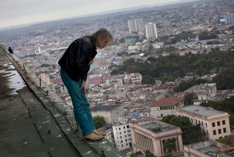 Alain Robert known as "Spiderman," looks over the edge from the roof of the Habana Libre hotel in Havana, Cuba, Friday, Feb. 1, 2013. (AP Photo/Ramon Espinosa)