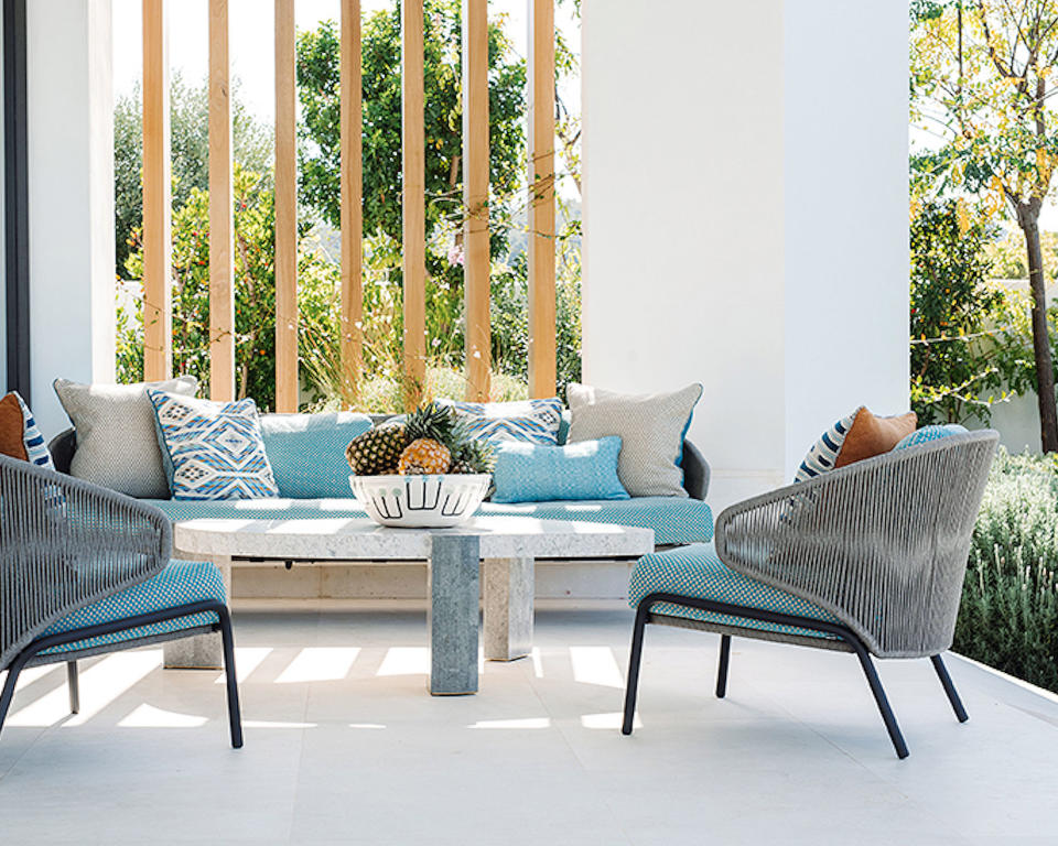 Outdoor living room with modern seating and stone floor and walls