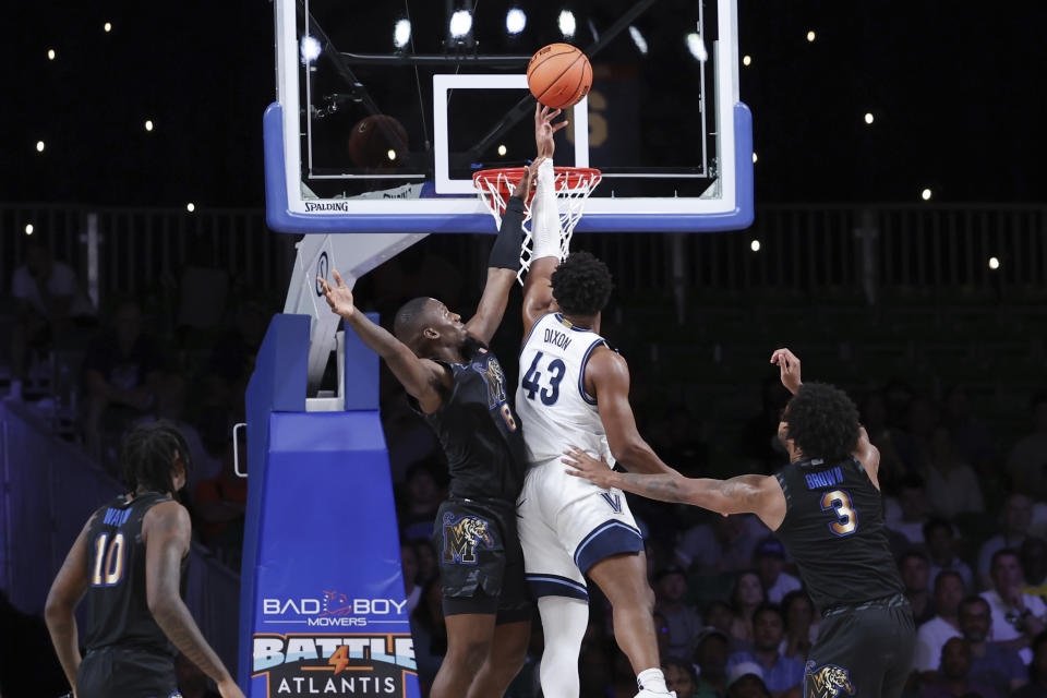 In a photo provided by Bahamas Visual Services, Villanova's Eric Dixon (43) goes for the lay up between Memphis' David Jones (8) and Memphis' Jordan Brown (3) during the first half of an NCAA college basketball game in the Battle 4 Atlantis at Paradise Island, Bahamas, Friday, Nov. 24, 2023. (Tim Aylen/Bahamas Visual Services via AP)