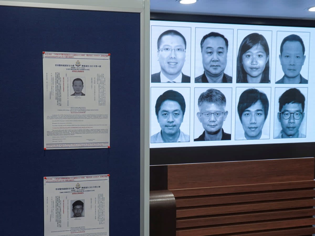 Photos of eight activists who have been issued arrest warrants over national security are displayed during a press conference in Hong Kong on 3 July (Reuters)