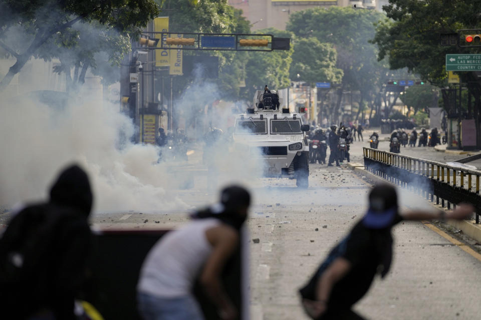 Manifestantes se enfrentan a la policía en las protestas contra los resultados de las elecciones que dieron por ganador a Nicolás Maduro, el día después de las votaciones en Caracas, Venezuela, el lunes 29 de julio de 2024. (AP Foto/Matías Delacroix)