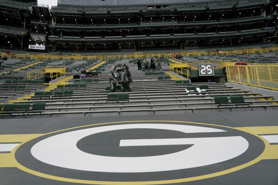 Fans take their socially distanced seats before an NFL divisional playoff football game between the Los Angeles Rams and Green Bay Packers, Saturday, Jan. 16, 2021, in Green Bay, Wis. (AP Photo/Morry Gash)