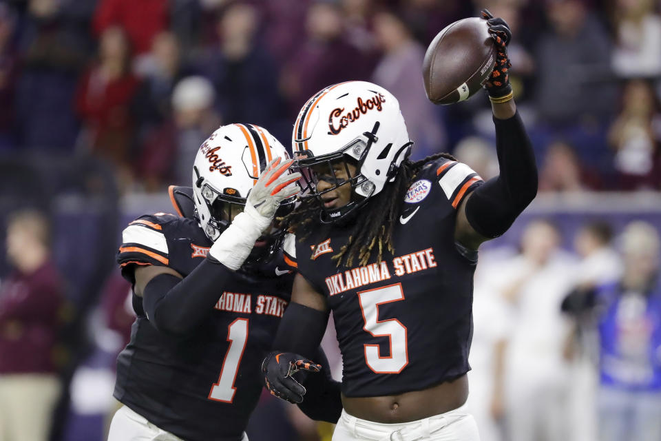 Oklahoma State linebacker Xavier Benson (1) and safety Kendal Daniels (5) celebrate Daniels' interception of a Texas A&M pass on the final play of the Texas Bowl NCAA college football game Wednesday, Dec. 27, 2023, in Houston. (AP Photo/Michael Wyke)