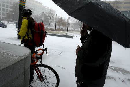 Commuters exit the Metrorail station as the snow begins to fall in Washington January 22, 2016. REUTERS/Jonathan Ernst
