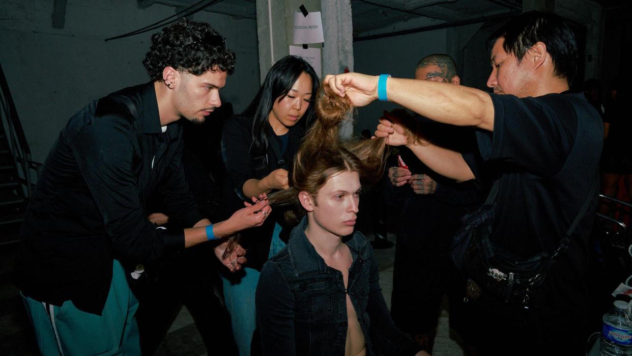 A model's hair is styled backstage at Prototypes