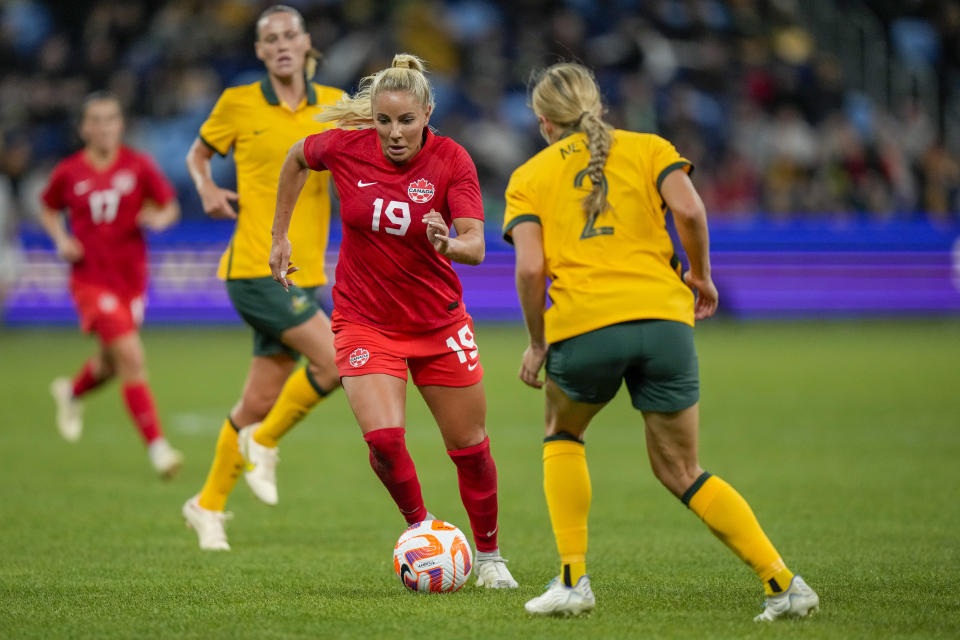Canada's Adriana Leon, centre, and Australia's Courtnet Nevin battle for the ball during a friendly soccer international between Canada and Australia in Sydney, Australia, Tuesday, Sept. 6, 2022. (AP Photo/Rick Rycroft)