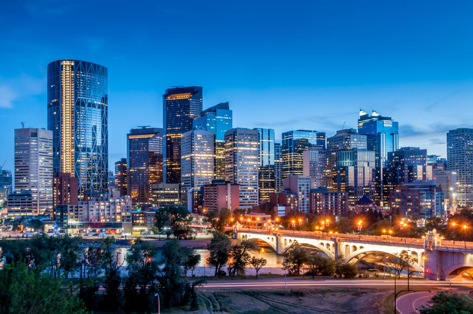 Calgary skyline at night with Bow River and Centre Street Bridge.