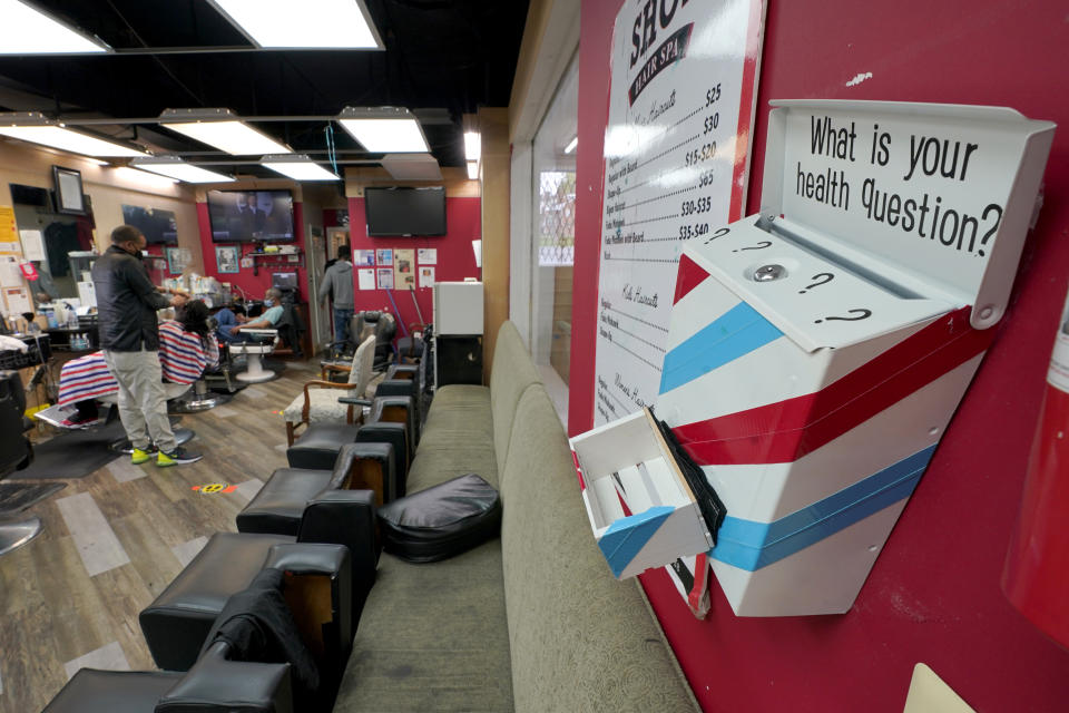 A box encouraging barber shop patrons to submit health questions is displayed at The Shop, Friday, April 9, 2021, in Hyattsville, Md. Barbers are member of the Health Advocates In Reach & Research (HAIR) program, which helps barbers and hair stylists to get certified to talk to community members about health. During the COVID-19 pandemic, a team of certified barbers have been providing factual information to customers about vaccines, a topic that historically has not been trusted by members of black communities because of the health abuse the race has endured over the years. (AP Photo/Julio Cortez)