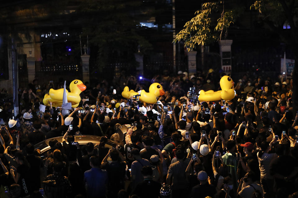 Pro-democracy protesters carry large inflatable ducks over the crowd during an anti-government rally in Bangkok, Thailand, Wednesday, Nov. 18, 2020. Police in Thailand's capital braced for possible trouble Wednesday, a day after a protest outside Parliament by pro-democracy demonstrators was marred by violence that left dozens of people injured. (AP Photo/Sakchai Lalit)