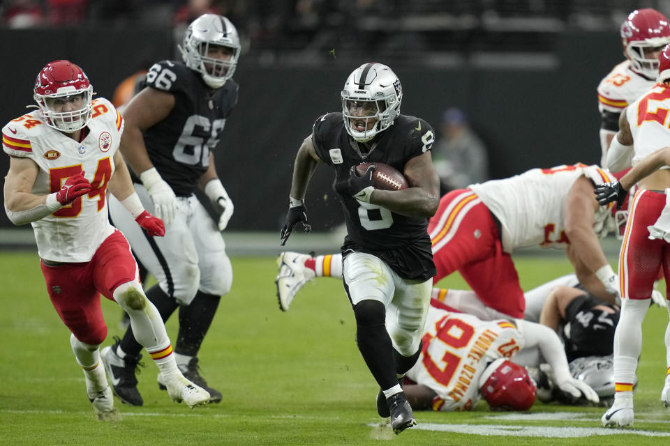 Las Vegas Raiders running back Josh Jacobs (8) runs past Kansas City Chiefs defenders to score during the first half of an NFL football game, Sunday, Nov. 26, 2023, in Las Vegas. (AP Photo/John Locher)