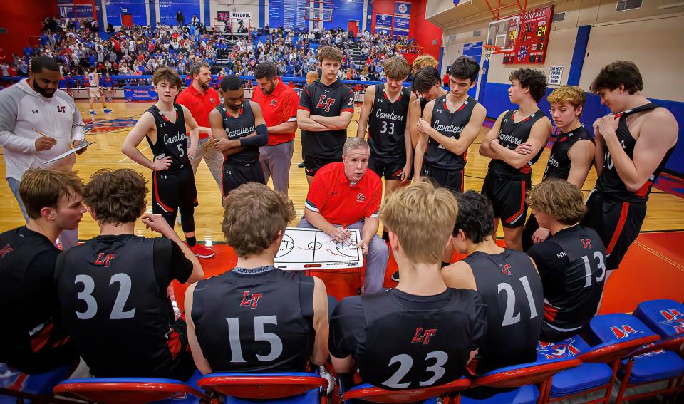 Lake Travis coach Clint Baty draws up a play and talks to his team before the start of the fourth period of the game against Westlake on Feb. 8. Baty, who has coached the Cavaliers since 2011, announced his retirement on Monday.