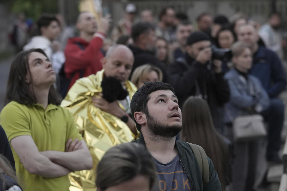 Evacuated residents look at their multi-story apartment building which was damaged during Russian attack in Kyiv, Ukraine, Tuesday, May 30, 2023. (AP Photo/Roman Hrytsyna)