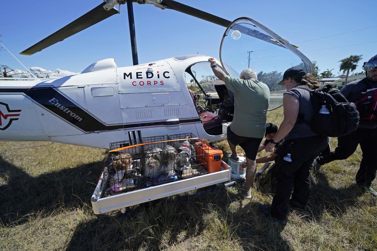 Members of mediccorps.org, who arrived with two helicopters, paramedics and volunteers, help evacuate Paul Koch and some of his dogs in the aftermath of Hurricane Ian on Pine Island, Fla., Saturday, Oct. 1, 2022. The only bridge to the island is heavily damaged so it can only be reached by boat or air.