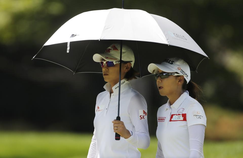 South Korea's Na Yeon Choi, left, and teammate Jenny Shin walk the first fairway during the third round of the Dow Great Lakes Bay Invitational golf tournament, Friday, July 19, 2019, in Midland, Mich. (AP Photo/Carlos Osorio)