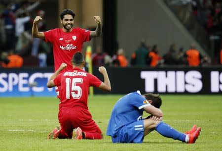 Football - Dnipro Dnipropetrovsk v Sevilla - UEFA Europa League Final - National Stadium, Warsaw, Poland - 27/5/15 Dnipro's Yevhen Seleznyov looks dejected after the game as Sevilla's Benoit Tremoulinas and Timothee Kolodziejczak celebrate winning the UEFA Europa League Final Reuters / Stefan Wermuth