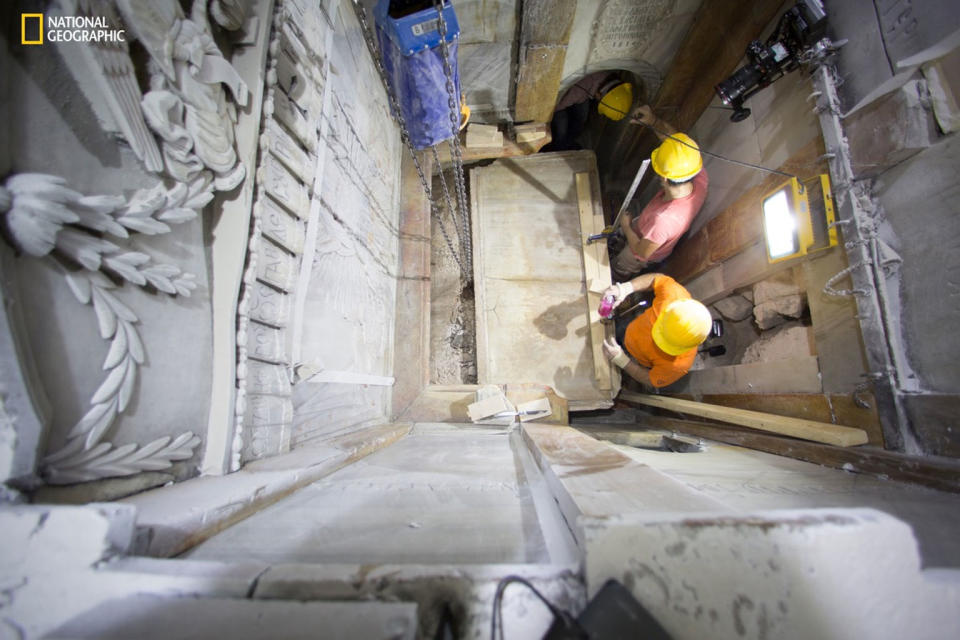 Workers remove a marble slab covering the original stone "burial bed" where Jesus Christ is said to have been laid to rest after being crucified. A layer of loose fill material is seen beneath. Scientists were surprised at how much of the original cave structure remained, said National Geographic archaeologist-in-residence Fredrik Hiebert. <cite>DUSAN VRANIC/NATIONAL GEOGRAPHIC</cite>