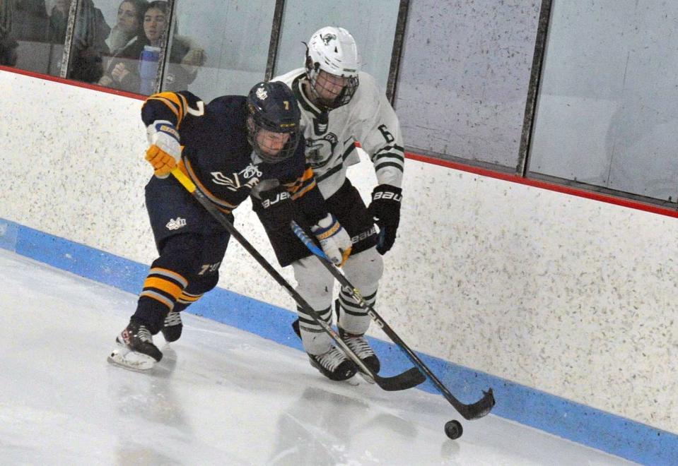 Cohasset/Hull's Robbie Casagrande, left, and Abington's Sam McDonald, right, battle at the boards for the puck during boys high school hockey at the Rockland Ice Rink, Monday, Feb. 12, 2024.