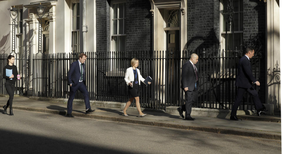 Members of a meeting keep their distance as they arrive at 10 Downing Street as British Prime Minister Boris Johnson was moved to intensive care after his coronavirus symptoms worsened in London, Tuesday, April 7, 2020. Johnson was admitted to St Thomas' hospital in central London on Sunday after his coronavirus symptoms persisted for 10 days. Having been in hospital for tests and observation, his doctors advised that he be admitted to intensive care on Monday evening. The new coronavirus causes mild or moderate symptoms for most people, but for some, especially older adults and people with existing health problems, it can cause more severe illness or death.(AP Photo/Matt Dunham)
