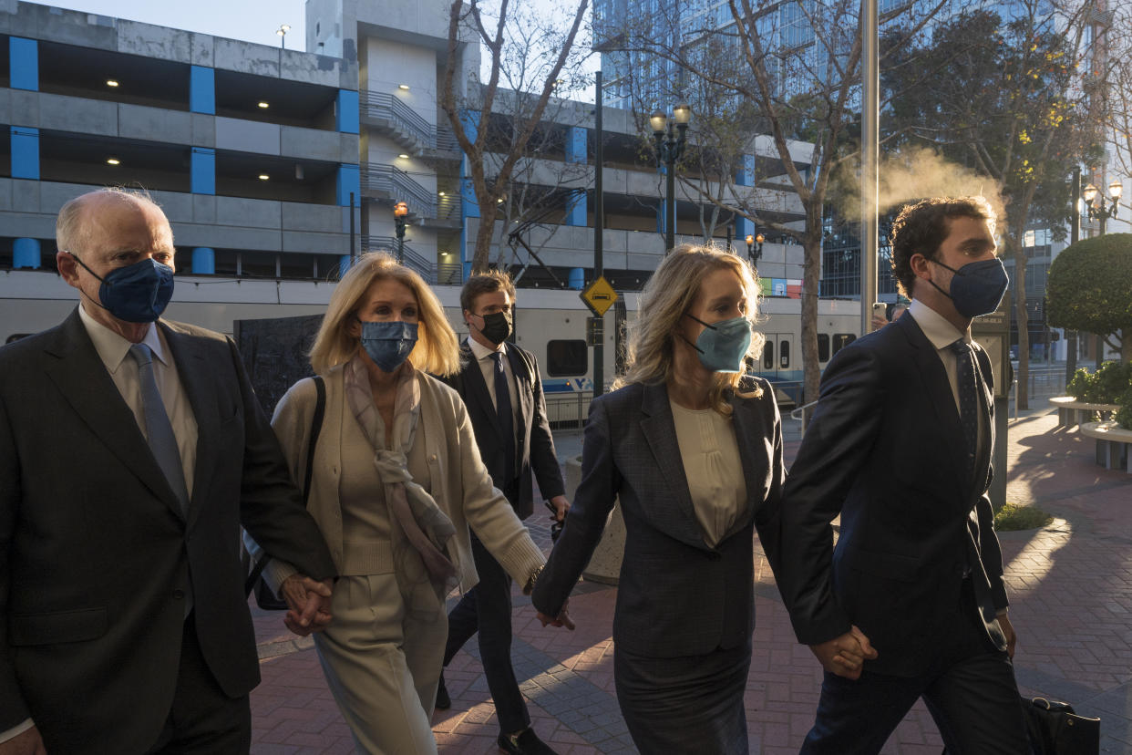 Former Theranos CEO Elizabeth Holmes, second from right, walks into federal court for her trial in San Jose, Calif., Friday, Dec. 17, 2021. (AP Photo/Nic Coury)