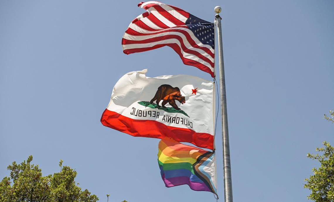 A Pride flag flies along with the American and California flags on the flag pole at Clovis Community College in Clovis following a ceremony with students and staff to recognize June as Pride Month at the campus on Thursday, June 1, 2023.