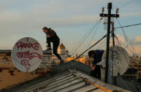 Georgy Lanchevskiy (L) and Konstantin Drykin of Rudex climb across a rooftop in Moscow, Russia, June 2, 2017. REUTERS/Maxim Shemetov