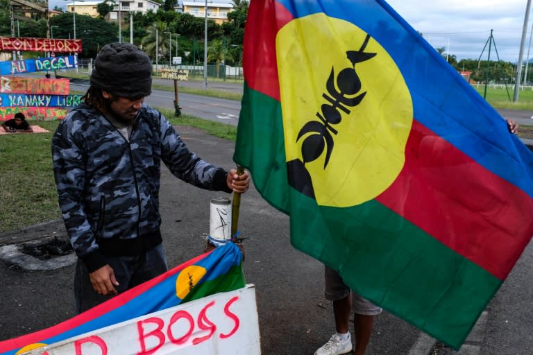 Un homme tient un drapeau kanak sur un campement indépendantiste à Rivière Salée en Nouvelle-Calédonie, le 12 juin 2024 (Thomas BERNARDI)