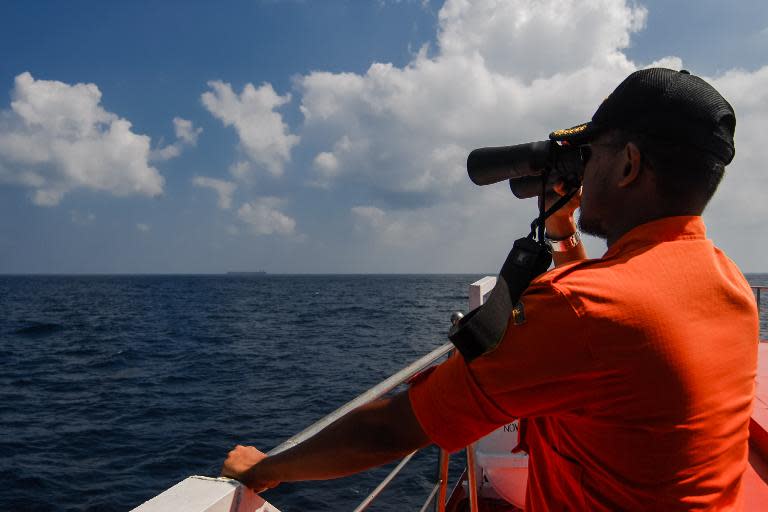 Indonesian National Search and Rescue Agency personnel scan the seas in the Malacca Strait off Aceh province on March 12, 2014 during the continued search for the missing Malaysia Airlines flight MH370