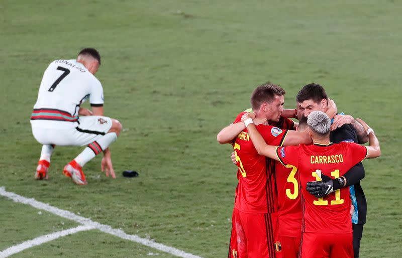 Foto del domingo de los futbolistas de Bélgica celebrando el pase a cuartos de final cerca del delantero de Portugal Cristiano Ronaldo