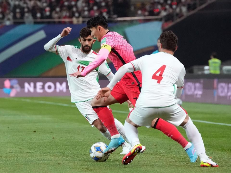 South Korea's Son Heung-min, centre, fights for the ball with Iran's Shojae Khalilzadeh and Ali Gholi Zadeh, left, in Seoul, South Korea on March 24, 2022. Families of those who died when Iranian forces shot down Flight PS752 say they want to see a planned match in Canada with Iran's team cancelled. (Ahn Young-joon/AP - image credit)