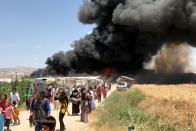 <p>Smoke rises after fire breaks out due to an unknown reason at the Qob Elias refugee camp at the Beqaa valley in Lebanon on July 1, 2017. (Hasan Jarrah/Anadolu Agency/Getty Images) </p>