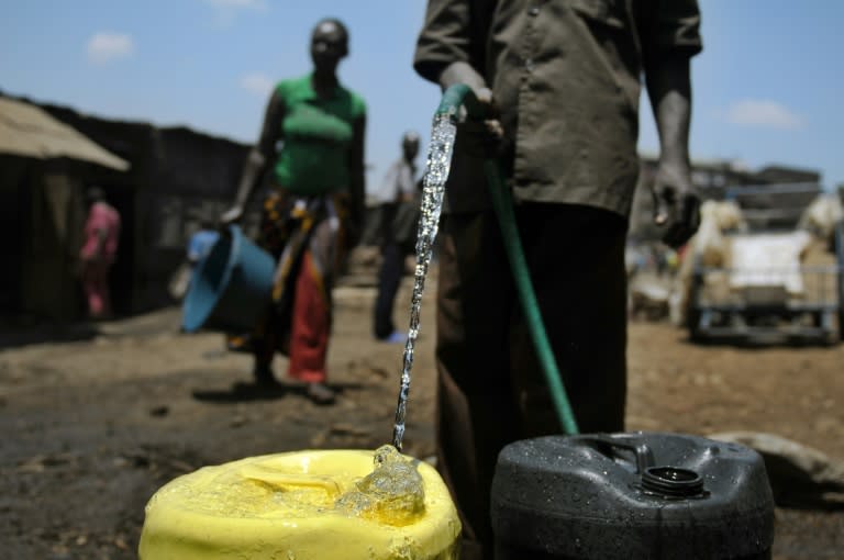 A local resident collects water in jerry cans in the Mathare slum in Nairobi